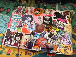 Photograph of Soarin's closed lid, which has been stickerbombed multiple layers deep with all manner of furry and non-furry stickers.